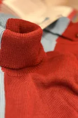 Polera de acrílico de dos colores, azul claro y bordó, con cuello alto.