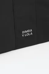 Bolso bandolera de tamaño mediano confeccionado en nylon negro, con estructura blanda, asa regulable de tejido, logo metálico de la marca en el frente y cierre con cremallera.