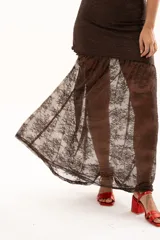 Vestido largo de encaje color chocolate, con escote halter y diseño ajustado en el torso que se abre en una falda con transparencia en el ruedo.