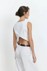 Top blanco sin mangas con espalda descubierta y diseño cruzado.