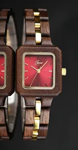 Reloj de pulsera con caja y malla de madera de nogal, esfera cuadrada color rojo rubí con detalles metálicos dorados y movimiento de cuarzo.