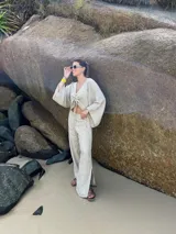 Pantalón largo blanco de lino, de corte recto y tiro alto, con abertura lateral en el ruedo.