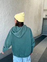 Buzo canguro verde con capucha y cordones ajustables.