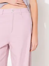 Pantalón jeanero de corte bombe, color rosa, confeccionado 100% en algodón, con recortes en delantero y rodilla.