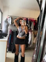 Top halter con escote drapeado y espalda descubierta, con estampado tipo tie-dye en tonos grises y blancos.