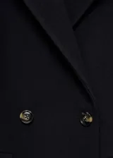 Abrigo de paño en mezcla de lana, con diseño cruzado, cierre frontal de botones, cuello con solapas de muesca y dos bolsillos laterales con solapa.