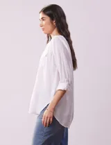 Blusa color beige de lino, marca Dash. Cuello a la base, escote en V y abertura con botones. Delantera con bolsillos. Largo de manga regulable con presilla y botón.