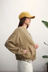 Chaqueta tipo bomber color negro, con cierre frontal metálico, cuello redondo y puños elásticos.