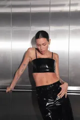 Pantalón negro de charol con tiro medio alto, botón metálico níquel, badana de RENÉE en cintura y bolsillos traseros.