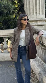 Blazer de corte sastrero con estampado de cuadros en tonos marrones y beige, con solapas clásicas, cierre frontal de dos botones y mangas largas con forro interno en contraste.