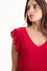Vestido corto de viscosa color beige, sin mangas con volados en las sisas, escote en V y diseño escalonado.