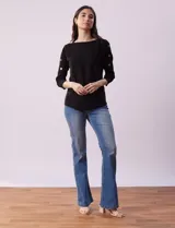 Buzo tejido color salmón de hilado fino, marca Cable & Gauge. Escote redondo con calados. Manga ¾, modelo dolman con aplique de botones dorados.