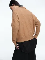 Sweater de tejido con textura peluda, color marrón, con cuello tipo polo y mangas largas. Presenta un diseño de silueta cómoda y holgada.
