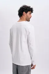 Remera manga larga blanca con cuello redondo y pequeño bordado circular con la frase "Good Ways" en el pecho.