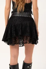 Pollera corta de encaje negro con diseño de vuelos y movimiento ligero, ideal para un look romántico y elegante.