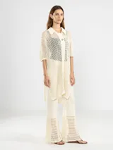 Camisa larga negra de punto calado con cuello camisero, manga tres cuartos y cierre frontal con botones.