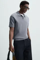 Polo de manga corta color verde oliva, con cuello solapa y abertura frontal tipo polo. Presenta una textura acanalada vertical y un calce regular.