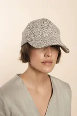 Gorra con visera confeccionada en lana fina sin teñir, con un sutil patrón de tejido en espiga.
