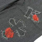 Pantalón gris con letras y rosas bordadas.