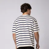 Remera tejida de manga corta en hilado 100% algodón, con diseño de rayas horizontales en color marrón y blanco, cuello redondo y calce relaxed.