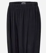 Pantalón estilo aladino color bordó, confeccionado en tejido crepé con textura. Presenta cintura elástica, corte holgado en las piernas y ruedo ajustado con lazo decorativo.