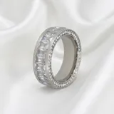 Anillo de acero con diseño de banda ancha, engastado con circonias en corte baguette y pavé en los bordes.