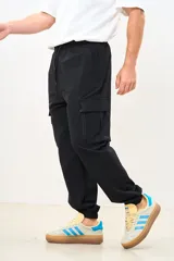 Pantalón cargo negro de corte ancho con bolsillos laterales con cierre y cintura ajustable con cordón.