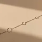 Pulsera de cadena de eslabones finos en plata 925, con tres aros circulares de diferentes tamaños intercalados en el diseño.