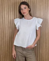 Musculosa blanca de lino, con cuello redondo y mangas cortas con volados.