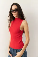 Musculosa negra de tejido de punto acanalado, con cuello alto y corte ajustado.