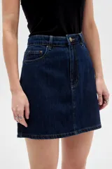 Minifalda de denim en color azul oscuro, con tiro alto, bolsillos delanteros y traseros, costuras en contraste y cierre frontal con botón y cremallera.