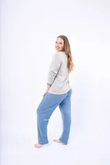 Pijama de dos piezas color coral, de lanilla, compuesto por una camisa de manga larga con botones y un pantalón largo.