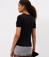 Remera de algodón con elastano, de corte ajustado, manga corta y cuello redondo. Presenta una estampa frontal de corazón con diseño tribal en color blanco sobre fondo negro.