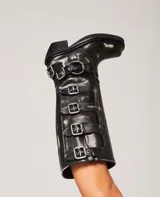 Botas de caña alta color marrón con múltiples hebillas metálicas.