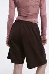 Short tipo bermuda de algodón fleece color gris claro, con cintura elastizada y bolsillos laterales.