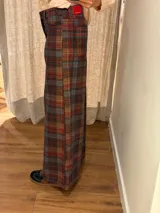 Pantalon de corte ancho y holgado, confeccionado en mezcla de algodón, viscosa y lino. Presenta costuras decorativas, pinzas debajo de la rodilla, bordado de monograma en el bolsillo delantero y pespuntes a contratono.