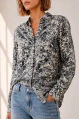 Camisa de manga larga con cuello clásico y cierre frontal de botones, con estampado botánico de hojas en tonos azules y blancos.