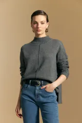 Polera de tejido de punto color blanco, con cuello alto acanalado, hombros caídos y detalle de costura vertical en el frente.