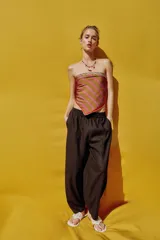 Pantalón de lino marrón oscuro, de corte barrel con pernera holgada que se estrecha hacia el tobillo, cintura elástica y bolsillos delanteros.