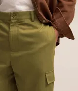 Pantalón cargo de algodón color verde oliva, corte sastrero, con bolsillos laterales tipo cargo, trabillas en la cintura, cierre tradicional y lazo ajustable en los bajos.