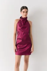 Vestido corto color fucsia, con escote halter y espalda media baja, confeccionado en tafeta con brillo.