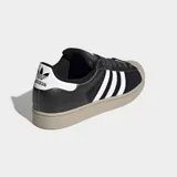 Championes Adidas Superstar II, color negro con las tres bandas características en blanco y suela de goma en tono tostado con la clásica puntera de goma.