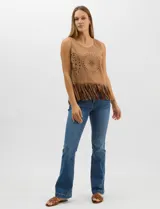 Blusa sin mangas de textura gamuzada color marrón, con escote redondo y corte recto. El frente presenta un diseño de calados circulares y geométricos, finalizando en un ruedo con flecos largos.