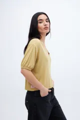 Remera color mostaza con escote en V, mangas abullonadas y corte crop.