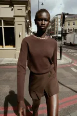 Falda pantalón corta de tiro alto con estampado animal print, cierre lateral oculto y aplique metálico triangular en la parte delantera.