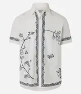 Camisa de manga corta confeccionada en algodón y lino, color blanco con bordado floral en negro.