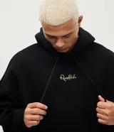 Buzo con capucha de corte boxy, confeccionado en tejido fleece. Presenta una estampa artística en la espalda que ilustra a un jugador de fútbol y firma bordada en el pecho.