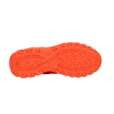 Championes deportivos Lotto para hockey, color naranja vibrante con detalles en blanco. Presentan un diseño robusto con suela dentada para mayor tracción y logo de la marca en el lateral.