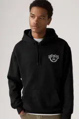Buzo tipo hoodie color negro, con capucha ajustable con cordones y bolsillo frontal tipo canguro. Presenta un estampado gráfico pequeño en el pecho con el logo de la marca rodeado por una corona de laureles.