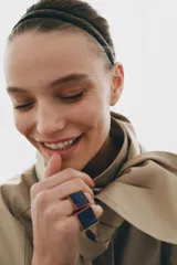 Anillo tipo sello de metal dorado con una piedra rectangular de lapislázuli incrustada.